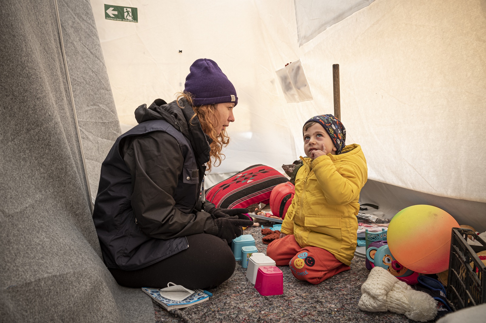 Gespräch zwischen Ärzte der Welt Mitarbeiterin und Kind in einem Zelt in der Türkei. © OLIVIER PAPEGNIES