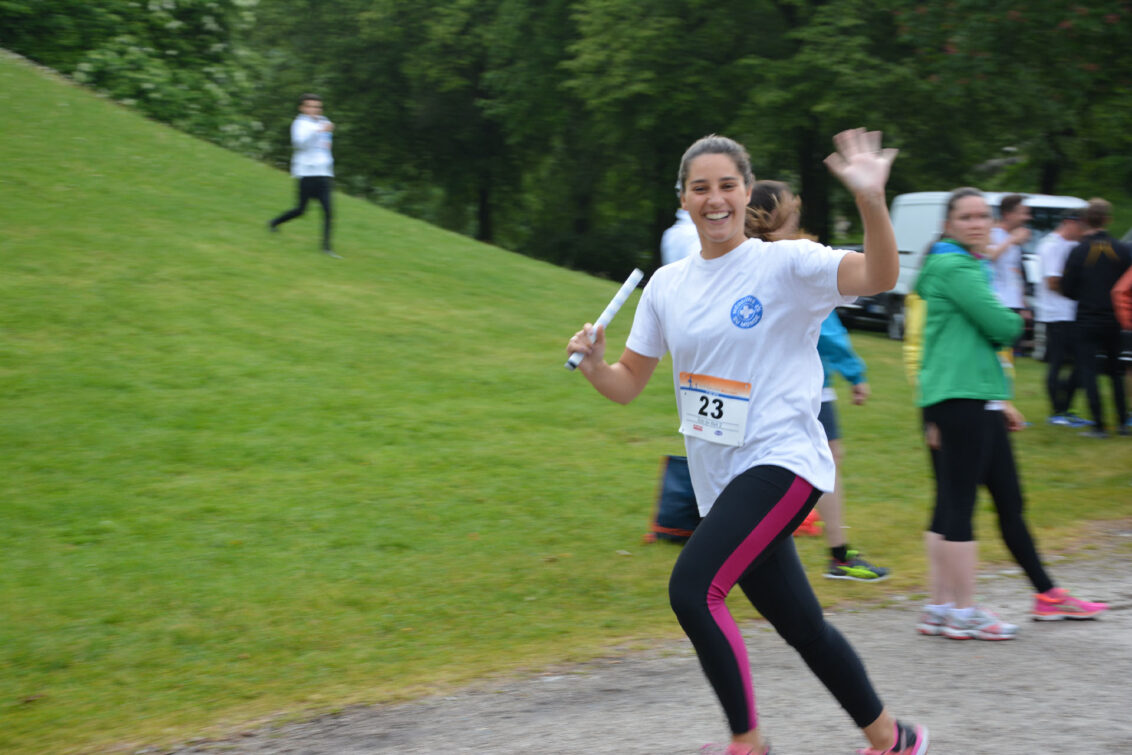 Eine junge Frau läuft unter dem Banner von Ärzte der Welt