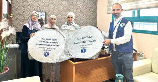 Mitarbeitende von Ärzte der Welt halten Schilder: Psychische Gesundheit ist so wichtig wie körperliche Gesundheit