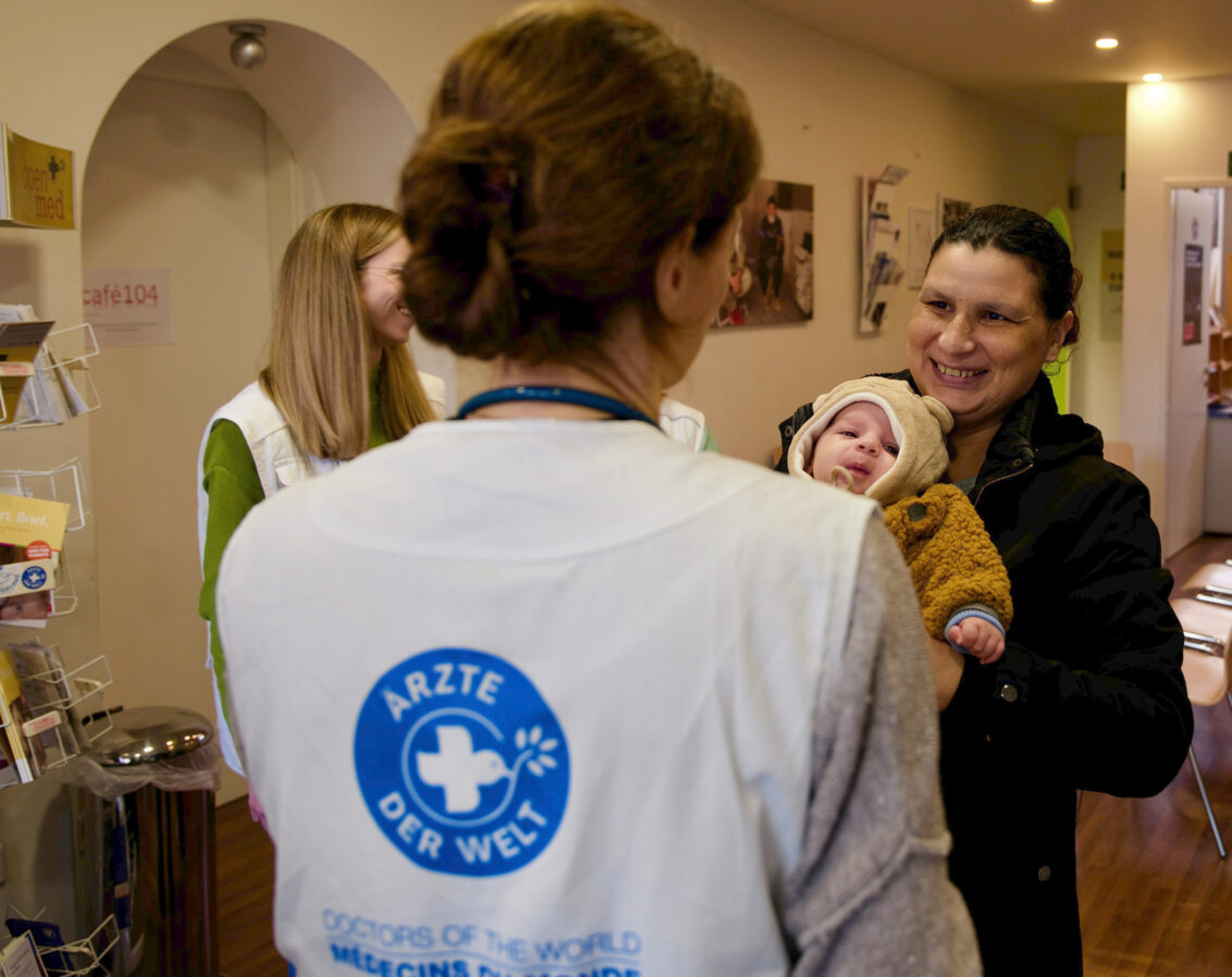 Deutschland: Sprechstunde bei open.med München mit ehrenamtlicher Ärztin, einer Mutter und ihrem Baby.