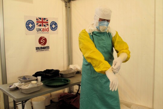 Symbolbild: Ein Mitarbeiter von Médecins du Monde zieht in einem Gesundheitszentrum in Sierra Leone seine Schutzausrüstung an. © Nick Harvey