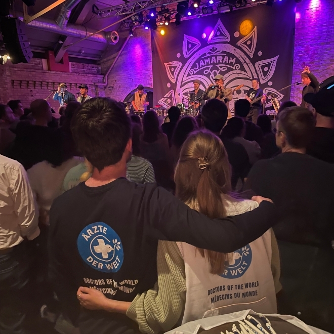 Bei einem Konzert der Reggae-Band Jamaran umarmen sich zwei Mitarbeiterinnen von Ärzte der Welt. © Ärzte der Welt