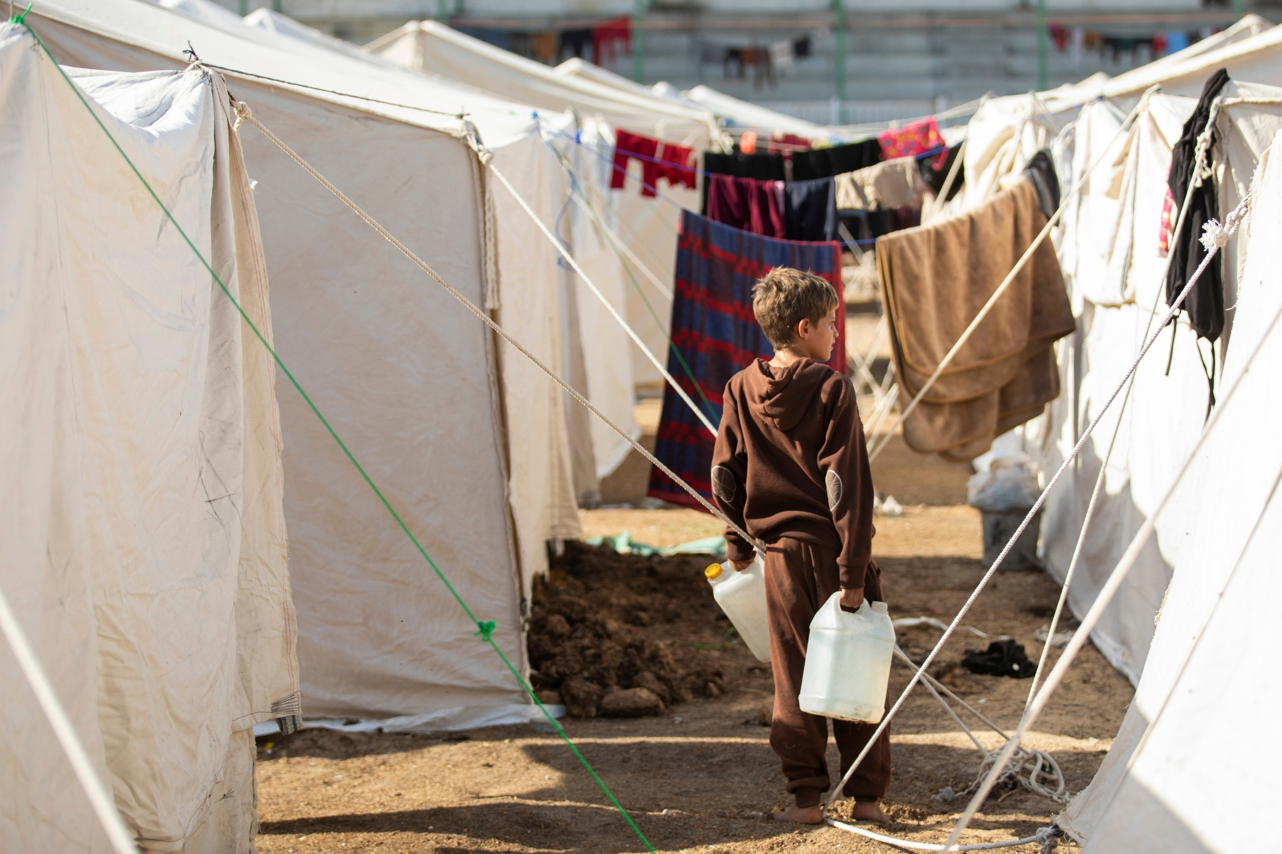 Ein kleiner Junge trägt Wasserkanister im Lager Yarmouk in Gaza © Moath Abu Al-Laban